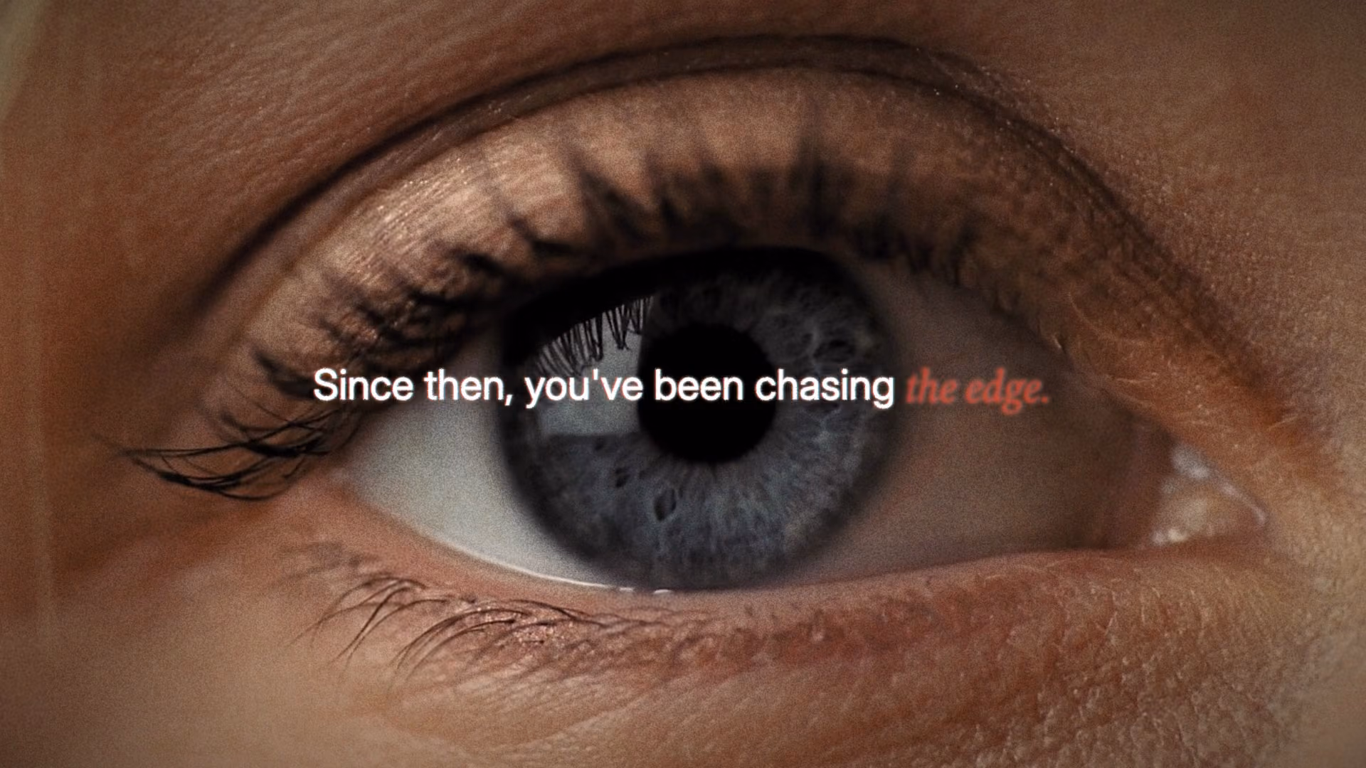 A frame from our Opus 5.5 film: a macro shot of an eye with the line, Since then, you have been chasing the edge.